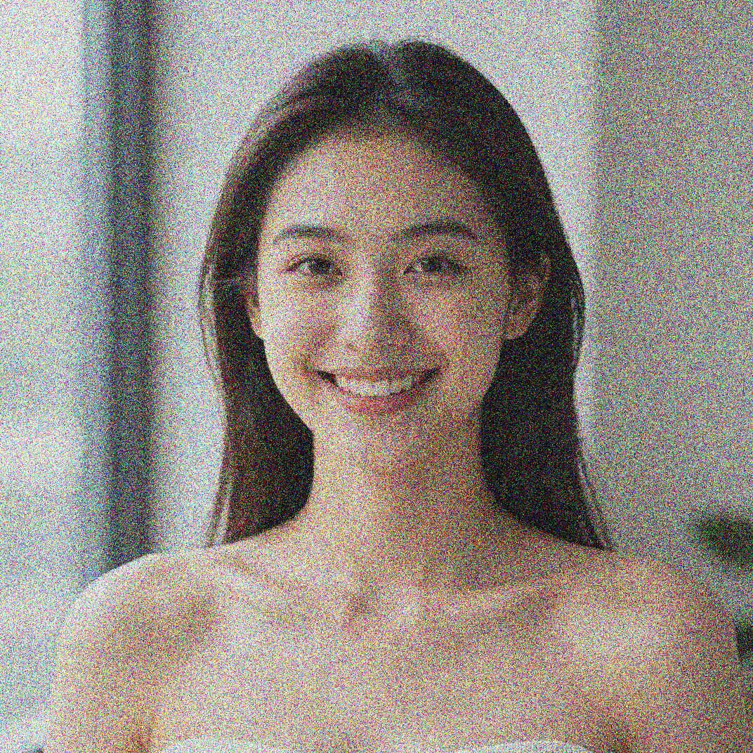 Grainy low-light portrait shot at high ISO with heavy color noise across the face before AI noise reduction